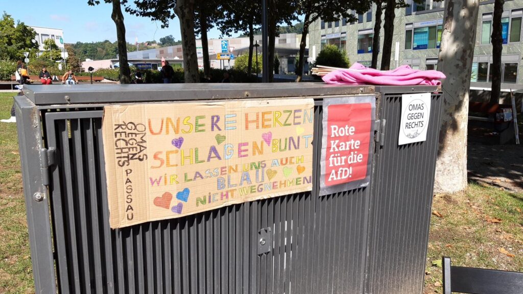 Ein buntes Plakat für Vielfalt am Stand der Omas Gegen Rechts im Klostergarten Passau.